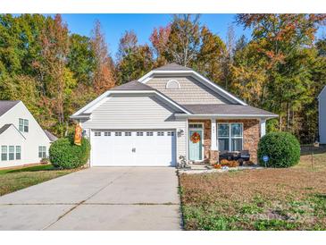 Charming home with a manicured lawn, stone accents, a cozy porch, and an attached two-car garage at 541 Settlers Grove Ln # 49, Salisbury, NC 28146