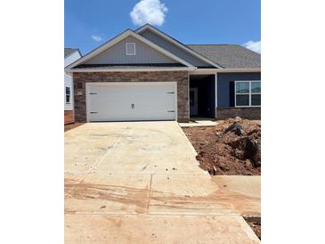 Charming single-story home featuring a stone facade, a two-car garage, and a well-manicured lawn at 5618 Skinny Dr, Charlotte, NC 28215