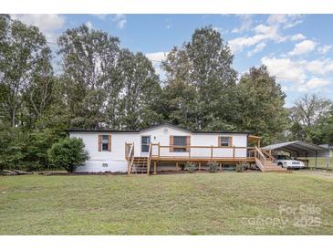 Charming home featuring a large front deck, a well-maintained lawn, and a carport at 6106 Ashley Dr, Concord, NC 28025