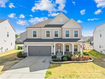 Charming two-story home featuring a well-manicured lawn, a gray two-car garage, and a welcoming front porch at 7314 Rupell Dr, Charlotte, NC 28273