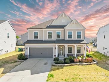 Charming two-story home featuring a two-car garage, landscaped yard, and covered front porch at 7314 Rupell Dr, Charlotte, NC 28273