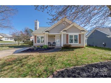 Charming single-story home with a well-maintained lawn, cozy front porch, and neutral siding at 114 Indian Paint Brush Dr, Mooresville, NC 28115