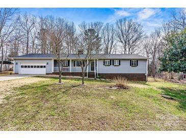 Charming single-story home with a front porch and attached garage, offering classic curb appeal at 1140 Knollwood Dr, Claremont, NC 28610