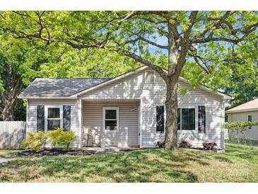 Charming single-story home featuring a well-manicured lawn, mature tree, and quaint front porch at 1509 Harrill St, Charlotte, NC 28205