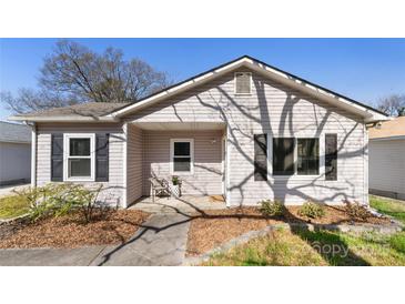 Charming single-story home with light siding, black shutters, and a cozy front porch at 1509 Harrill St, Charlotte, NC 28205