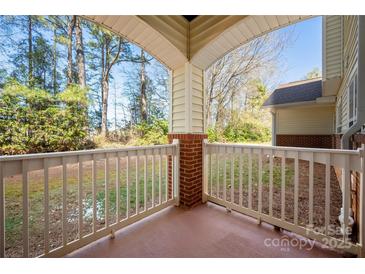 Inviting covered porch with brick detail and views of a wooded landscape, perfect for relaxing at 16312 Redstone Mountain Ln, Charlotte, NC 28277