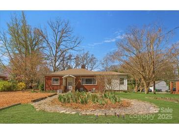 Charming brick home with a metal roof, a well-manicured front yard, and mature trees at 1815 W Sugar Creek Rd, Charlotte, NC 28262