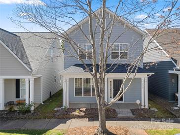 Charming gray two-story home featuring a covered front porch and landscaped front yard with walkway at 232 Faust Rd, Davidson, NC 28036