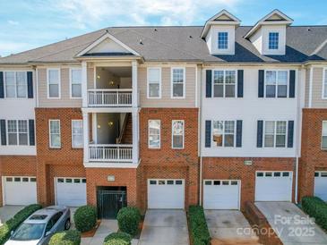 Attractive townhome showcases brick facade, dormers, balconies, and attached garages with private driveways at 6724 Mallard Park Dr, Charlotte, NC 28262