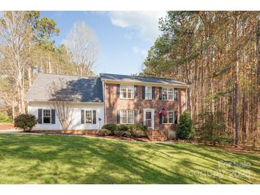 Charming two-story brick home with a well-manicured lawn and mature trees, creating a serene and inviting curb appeal at 7025 Ridgeway Rd, Stanley, NC 28164