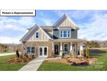 Charming two-story home with stone and siding exterior, inviting front porch, and well-manicured lawn at 1037 Merganser Way, Indian Trail, NC 28079