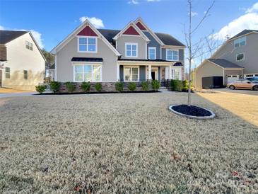Charming two-story home featuring a manicured lawn, beautiful landscaping, and traditional architectural details at 15827 Arabian Mews Ln, Charlotte, NC 28278