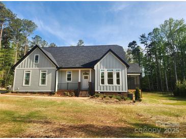 Charming single-Gathering home featuring a classic design, manicured lawn, and inviting front porch at 409 Henry Chapel Rd, Belmont, NC 28012