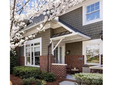 Charming home featuring neutral siding, brick accents, a covered entryway, and lush landscaping at 6301 Park South Dr, Charlotte, NC 28210