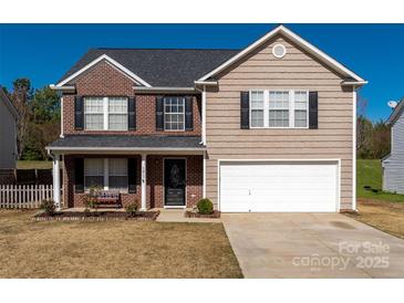 Charming two-story home featuring a brick facade, attached two-car garage and manicured front lawn at 1017 Village Green Ln, Rock Hill, SC 29730