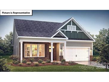 Charming home with a mix of brick and siding, a well-manicured lawn, and a welcoming two-car garage at 1055 Merganser Way, Indian Trail, NC 28079
