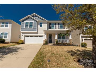 Charming two-story home with a well-manicured lawn and a welcoming front porch at 1519 Arcadia Bluff Dr, York, SC 29745