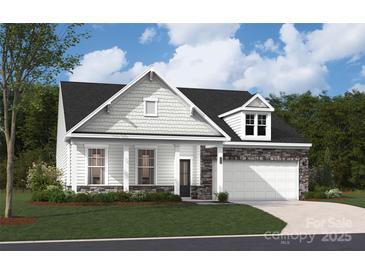 Inviting home featuring a stone-accented garage, manicured lawn, and classic architectural details at 2029 Mantle Ridge Dr, Indian Trail, NC 28079