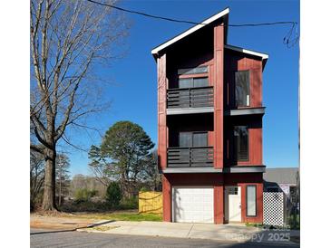 Modern three-story home featuring a garage, front door, and balconies on a sunny day at 211 S Webb St, Gastonia, NC 28052