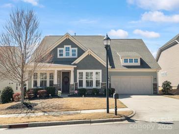 Charming single-Gathering home featuring a well-manicured lawn, gray siding, and attached two-car garage at 2253 Prairie Rd, Concord, NC 28027