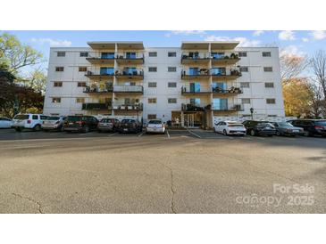 Multi-level condo building featuring private balconies and a well-maintained parking lot at 2503 Roswell Ave # 208, Charlotte, NC 28209