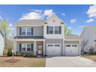 Charming two-story home featuring a two-car garage and beautifully landscaped front yard, with light-grey siding at 314 Contentment Dr # 192B, Locust, NC 28097