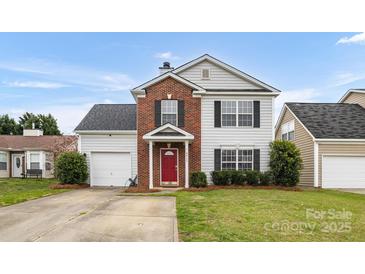 Charming two-story home featuring a red front door, brick accents, green lawn, and attached garage at 4917 Spruce Peak Rd, Charlotte, NC 28278