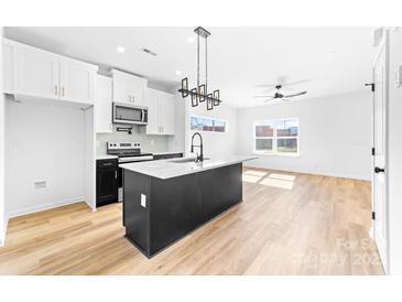 Modern kitchen with a large island, stainless steel appliances, and wood flooring at 600 Legrand St, Shelby, NC 28150