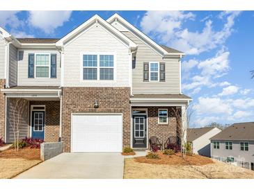 Inviting brick townhome featuring a one-car garage, covered porch, and charming exterior design at 6048 Chelsea Oaks Rdg, Tega Cay, SC 29708