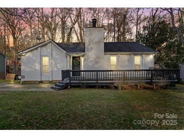 Charming exterior with a cozy front porch and white siding, surrounded by mature trees at 8220 Terra Linda Ln, Charlotte, NC 28215
