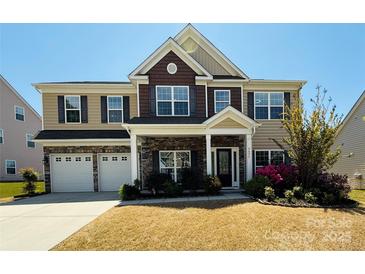 Charming two-story home with stone accents, manicured lawn, and a two-car garage at 9895 Travertine Trl, Davidson, NC 28036