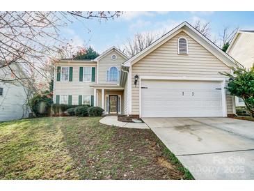 Traditional two-story home featuring a front lawn and two-car garage at 10434 Henbane Ct, Charlotte, NC 28213