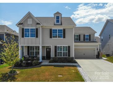 Charming two-story home with a well-manicured lawn, dormer, and attached two-car garage at 2010 Saddlebred Dr, Iron Station, NC 28080