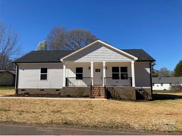 Charming single-story home featuring a classic covered front porch and neatly landscaped yard at 2037 Powerline Dr, Gastonia, NC 28054