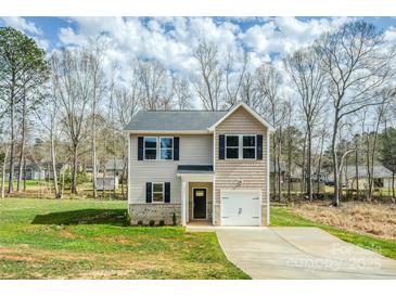 Charming two-story home featuring a well-manicured lawn and a single-car garage, all in a peaceful, wooded setting at 2591 Watson Dr, Lancaster, SC 29720