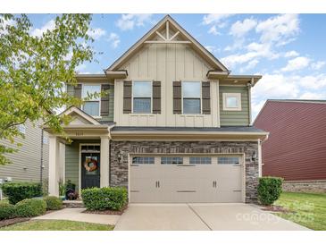 Charming two-story home featuring a stone facade, attached two-car garage, and a welcoming front entrance with a wreath at 3614 Dolly Madison Rd, Charlotte, NC 28208