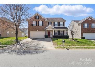 Charming two-story home with a brick and beige facade, two-car garage, manicured lawn and a red front door at 3812 Caldwell Ridge Pkwy, Charlotte, NC 28213