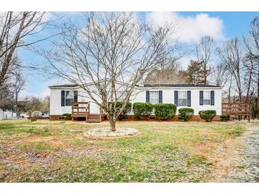 Charming single-story home featuring tidy landscaping, a covered porch, and traditional shutters for a welcoming curb appeal at 405 Briarwood Ct, Mount Holly, NC 28120
