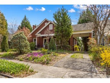 Charming brick home featuring mature landscaping, a covered carport, and beautiful curb appeal at 719 N Fulton St, Salisbury, NC 28144