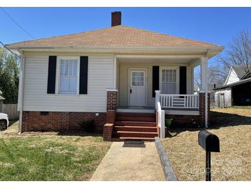 Charming single-story home featuring a cozy front porch, brick foundation, and well-maintained yard at 915 Spruce St, Albemarle, NC 28001