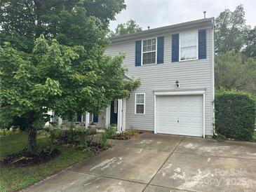 Two-story home with vinyl siding, blue shutters, a single-car garage, and mature landscaping at 1017 Chalk Hill Ln, Charlotte, NC 28214