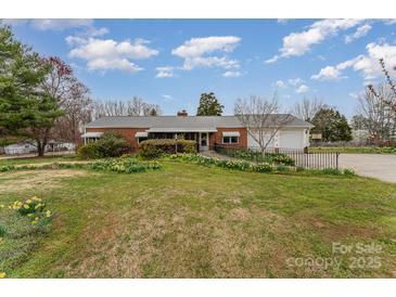 Charming brick home with a metal roof, well-maintained landscaping, and an accessible ramp at 230 Dunham Ave, Salisbury, NC 28146