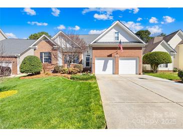 Charming brick home featuring an attached two-car garage and a meticulously manicured front lawn at 2966 Huckleberry Hill Dr, Fort Mill, SC 29715