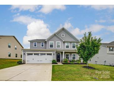 Charming two-story home with a well-maintained lawn and a three car garage in a suburban neighborhood at 7027 Waterwheel St, Concord, NC 28025