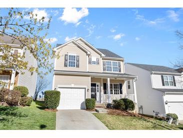 Charming two-story home with a well-maintained lawn, attached garage, and covered front porch at 11331 Breezehill Ln, Charlotte, NC 28262