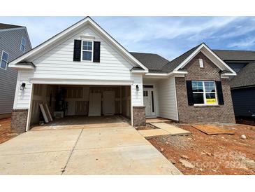 New construction home with brick and siding exterior, open garage, and partially finished landscaping at 1453 Ardmore Dr # 240, Sherrills Ford, NC 28673