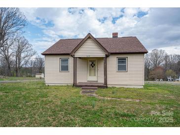 Charming single-story home with tan siding, a cozy front porch, and a well-manicured lawn at 2915 Spencer Ne Rd, Conover, NC 28613