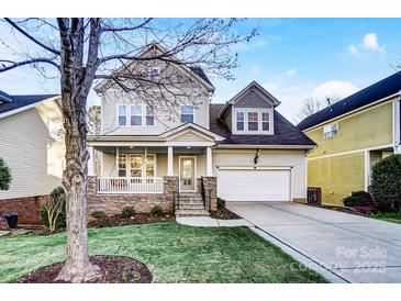 Charming two-story home with a well-manicured lawn, stone accents, and an attached two-car garage at 5807 Mctaggart Ln, Charlotte, NC 28269