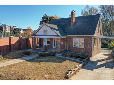 Charming brick home with well-kept lawn and mature trees, offering classic curb appeal and a welcoming ambiance at 610 Hawthorne Ln, Charlotte, NC 28204