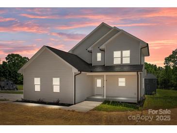 Stunning two-story home with a beautifully illuminated exterior at dusk at 106 Desert Sky Ct, Statesville, NC 28625